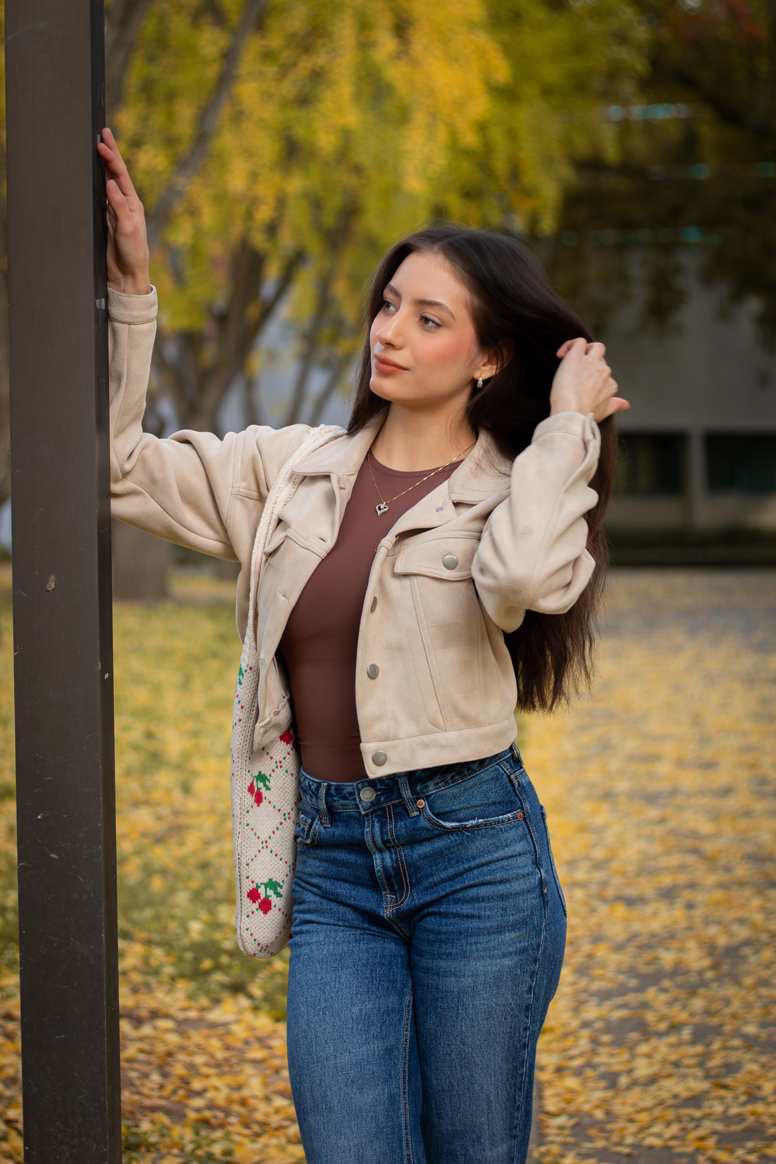 Finished portrait of a woman in a cream jacket beneath golden autumn trees