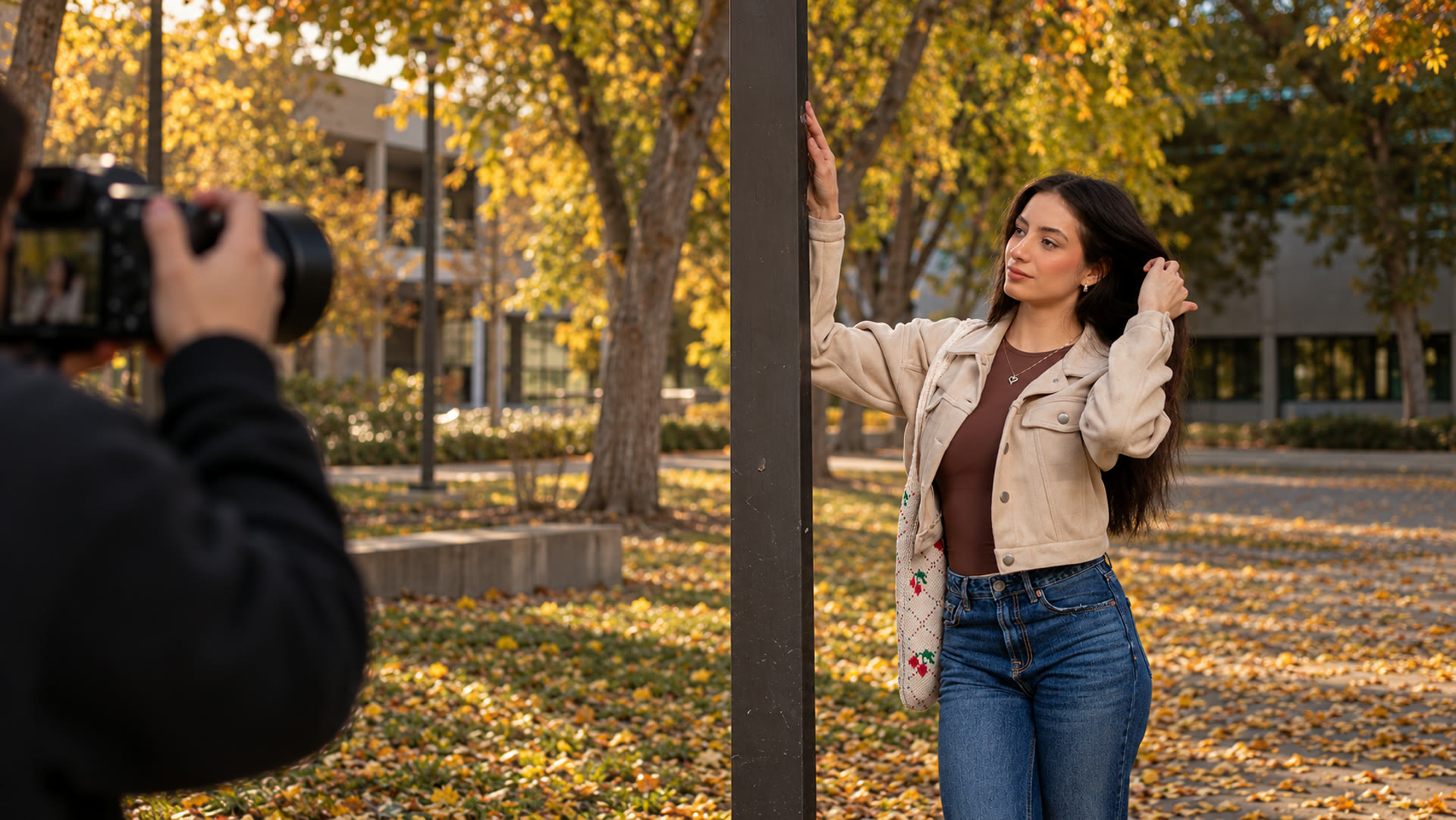 AI-created imagining of an autumn portrait shoot, with a photographer framing a subject beside a post