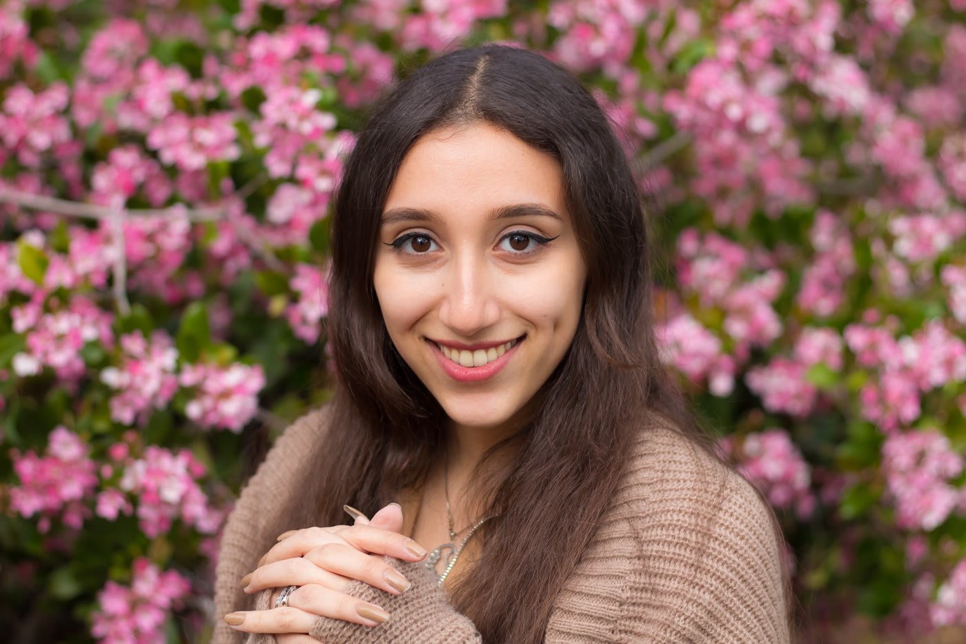 Smiling portrait in front of pink blossoms