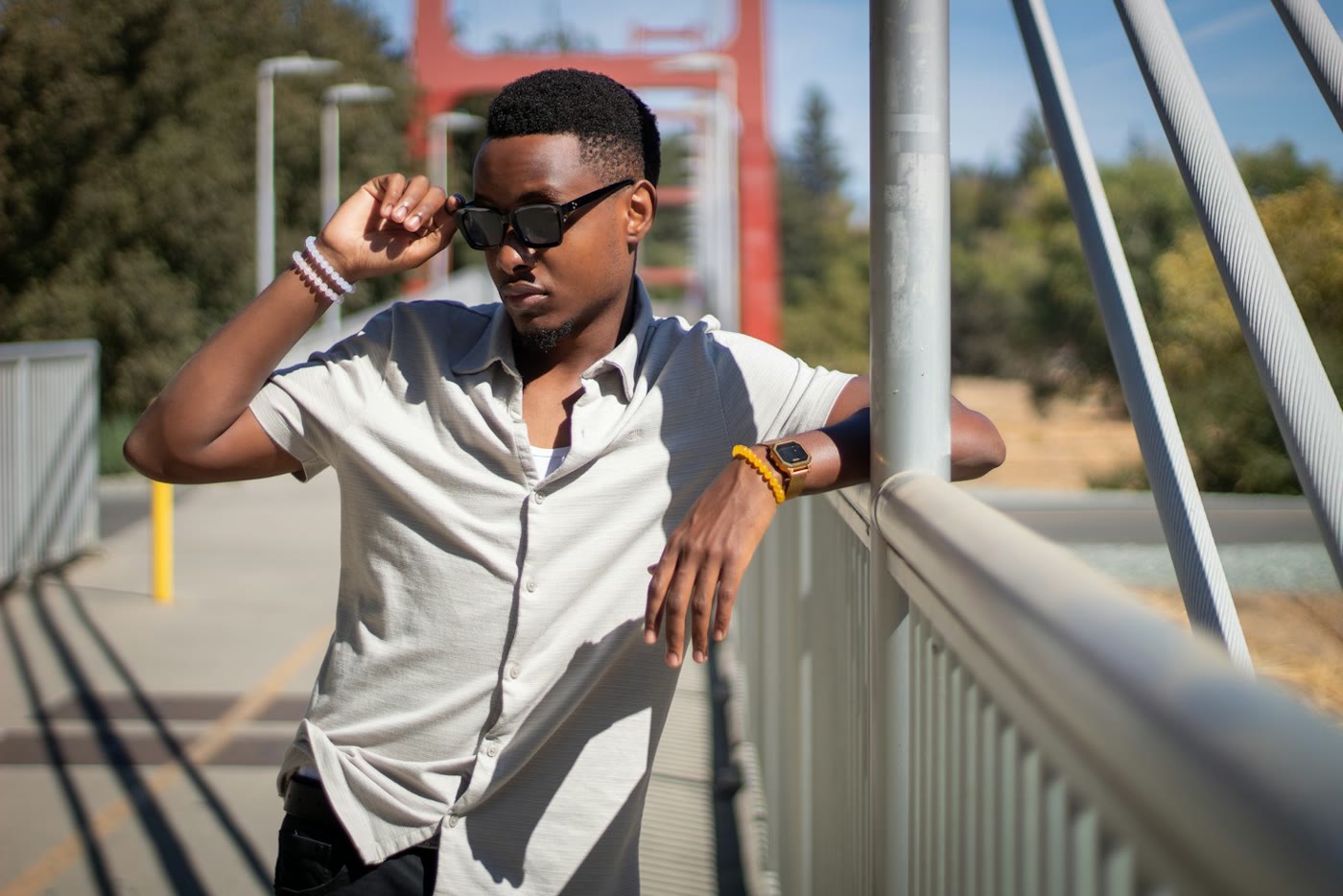 Man in sunglasses leaning on a metal railing