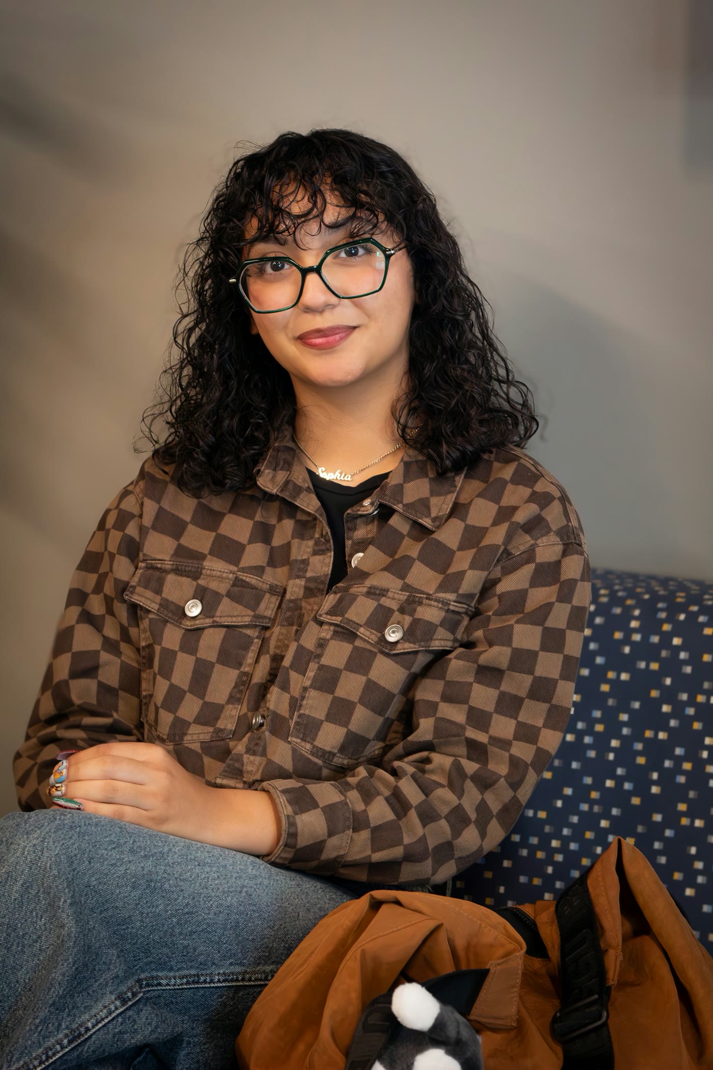 Studio portrait of a woman with glasses and curly hair